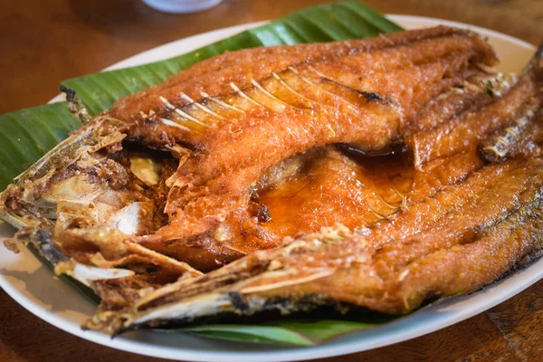 Tabakta kızarmış balık ve ahşap kaplama.