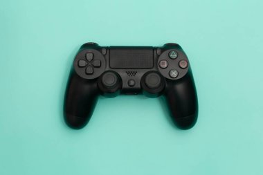 Turkuaz arkaplanda siyah oyun denetleyici izole edildi.