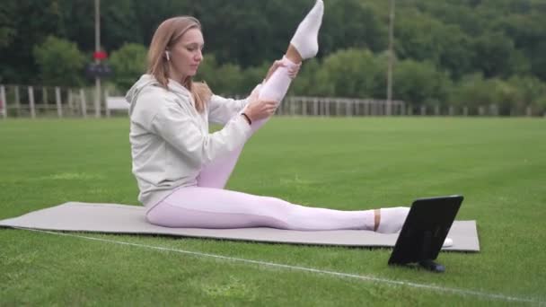 Woman starts fitness training using a tablet at the stadium