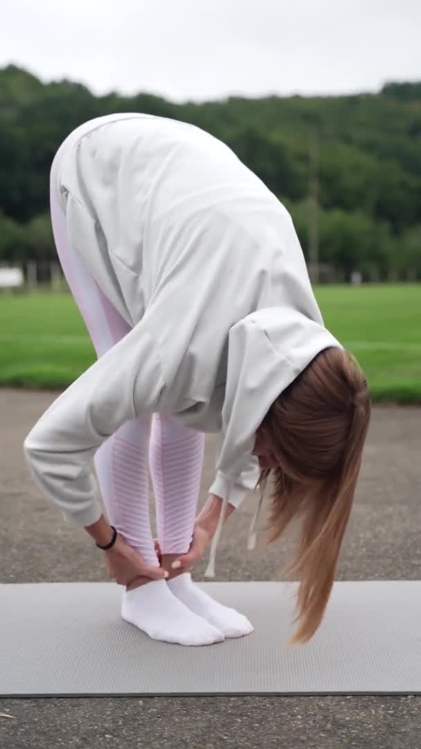 Uma Mulher Estende Músculos Das Costas Fazendo Curvas Tronco Até — Vídeo de Stock