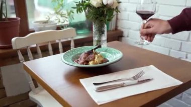 Restoranda güzel servis edilmiş patates püresi, tavuk budu ve kırmızı şarap.
