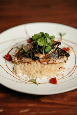 Beyaz tabakta ızgara uskumru ve kuskus.