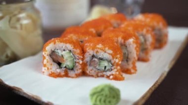 Kamera suşinin etrafında daireler çiziyor. Beyaz kilden bir tabakta.