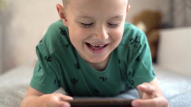 Mobil oyun oynayan neşeli çocuk