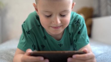 Close-up, the boy looks at the phone screen