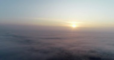 Gün batımında kamera bulutların üzerinde uçar.