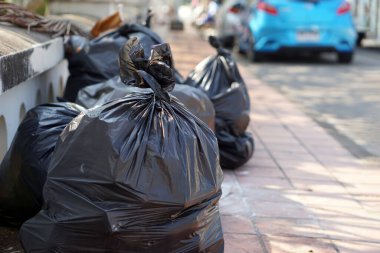 İçinde çöpler olan siyah plastik torbalar yığını. Çöpçü memurların onları götürmesini bekliyorlar. Atık yönetimi kavramı. İmha için toplandı.                 