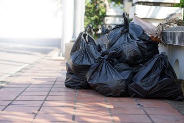 İçinde çöpler olan siyah plastik torbalar yığını. Çöpçü memurların onları götürmesini bekliyorlar. Atık yönetimi kavramı. İmha için toplandı.                 
