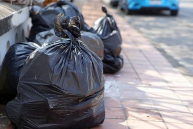 İçinde çöpler olan siyah plastik torbalar yığını. Çöpçü memurların onları götürmesini bekliyorlar. Atık yönetimi kavramı. İmha için toplandı.                    