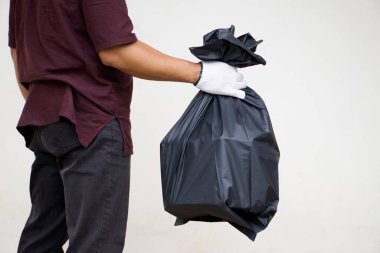 Adamın elinde içinde çöp olan siyah plastik torba var. Atık yönetimi kavramı. Çevre sorunları. Günlük ev işleri. Çöpü at..