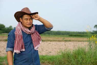 Asyalı çiftçinin portresi tarım çiftliğinde yorgun ve sıcak hissediyor. Konsept: his ve duygular. Çiftçi yoksulluğa karşı sıkı çalışır. Çiftçinin hayatı.