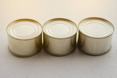 Yiyecek içeren üç teneke alüminyum kutu. Konsept: Geri dönüşüm olabilecek yiyecek veya içecek kabı. 