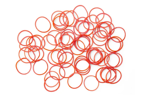 Beyaz arka planda elastik kırmızı lastik bantlar. Konsept: Bir şeyleri bağlamak için çok yönlü bir lastik bant, torbalar veya saç, birçok kez tekrar kullanılabilir.
