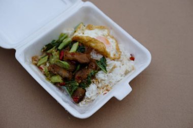 Kızarmış domuz eti, sebzeli lahana ve pirinçli sahanda yumurta, eve götürmek ya da ofiste yemek için. Tayland 'daki sokak yemekleri dükkanlarından kolay ve genel menü.                  