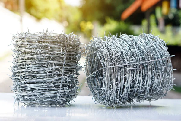 Rolls of barbed wire. Barbed wire is used for make fences , secure property and make border to show the territory of  area.