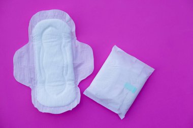 Pembe arka planda beyaz hijyenik ped. Konsept: Dönem için kadınların hijyenik ürünleri. Adet kanından iç çamaşırı lekelerine kadar koru. Kadın sağlık hizmetleri. Samimi hijyen. Üst görünüm.