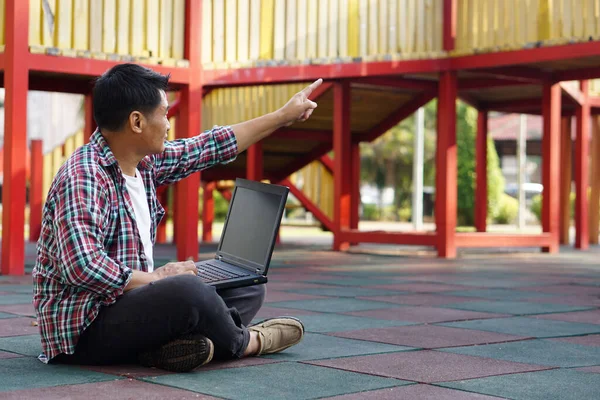 Asian Man Sits Outdoor Park Works Online Computer Laptop Points — Foto Stock
