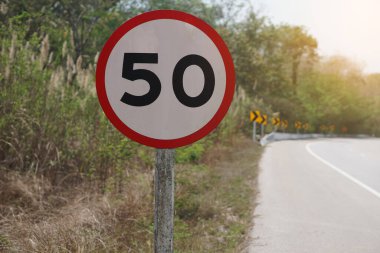 Tayland kırsalında yolun kenarına 50 numara işaretli daire şeklinde. Hız limiti 50 km. Viraj Caddesi 'nde yavaş sürüş uyarısı için saat başına. Trafik işareti..                  