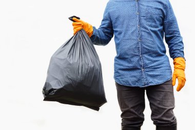 Yakındaki adam içinde çöp olan siyah plastik torbayı tutuyor. Beyaz arka plan. Atık yönetimi kavramı. Çevre sorunları. Günlük ev işleri. Çöpü at. . 