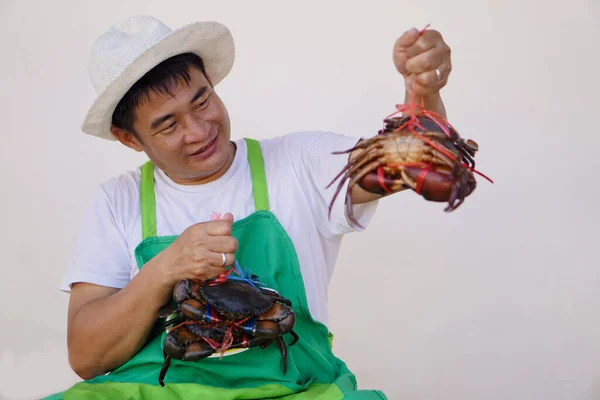 快乐英俊的亚洲男人海鲜商人戴着白色的帽子 绿色的围裙 露出螃蟹 小企业主 本地食品 — 图库照片
