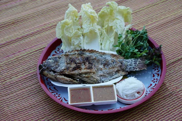 Tray of grilled fish, sauce, noodle and vegetables. Mat floor background. Concept : healthy food. Thai eating style for losing weight or on diet. Low fat