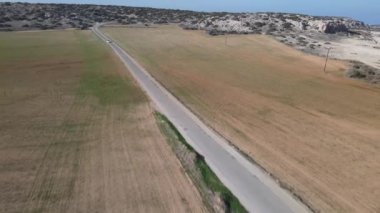 Denizin hava fotoğrafçılığı. Gündüz güneşi tarlayı aydınlatıyor. Kıbrıs Rum Kesimi 'nde araba yolculuğu