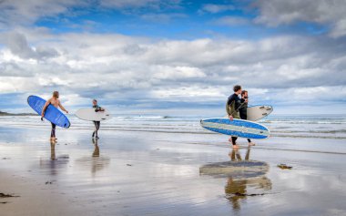 Bamburgh, Northumberland - 8 Eylül 2018: Sörfçüler Alnwick yakınlarındaki Bamburgh plajında bir gün geçirdikten sonra evlerine dönüyorlar