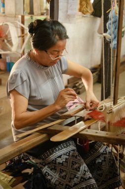 Vientiane, Laos - 14 Şubat 2018: Lao Tekstil 'deki dokuma tezgahları ve malzemeleri kullanan dokumacılar