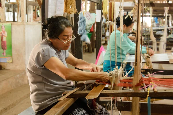 Vientiane, Laos - 14 Şubat 2018: Lao Tekstil 'deki dokuma tezgahları ve malzemeleri kullanan dokumacılar