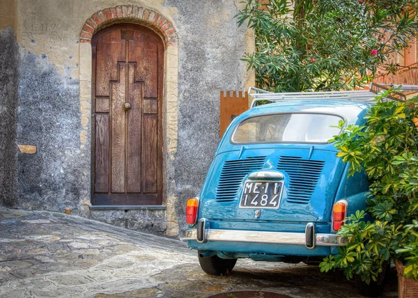 Sicilya, İtalya - 14 Ekim 2015: İlginç ahşap kapılı eski bir binanın yanına park edilmiş bir Fiat 600