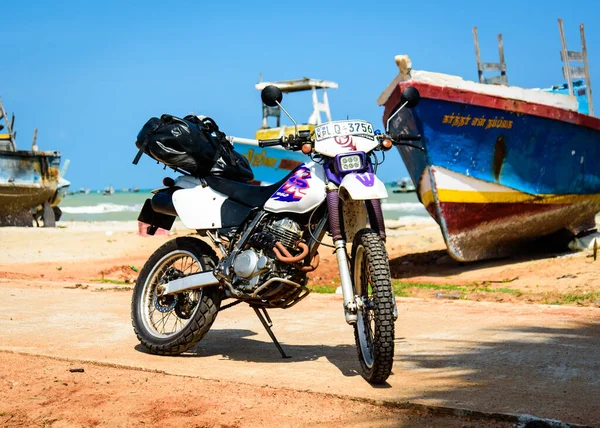 Isla Mannar, Sri Lanka - 11 de enero de 2020: Una motocicleta Honda alquilada estacionada junto a barcos pesqueros durante un recorrido por Sri Lanka. —  Fotos de Stock