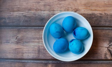 Mavi renkli yumurtalar arka planda açık sepetin içinde yatıyor. Paskalya