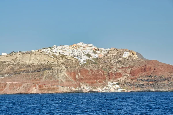 Yunanistan 'ın Santorini adasındaki Oia kasabası. Caldera, Ege denizi üzerinde mavi kubbeleri olan geleneksel ve ünlü evler ve kiliseler — Stok fotoğraf