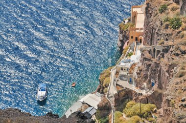 Santorini 'de mavi deniz ve bir tekne.