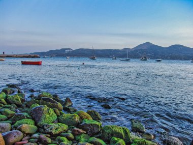 Yunanistan 'ın Milos adasında geleneksel evleri, renkli pencere ve kapıları olan manzaralı Yunan balıkçı köyü Klima