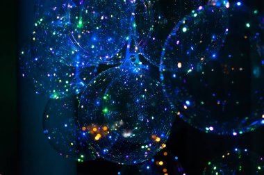 Şeffaf toplar, ışıklı sabun baloncuklarına benzer.