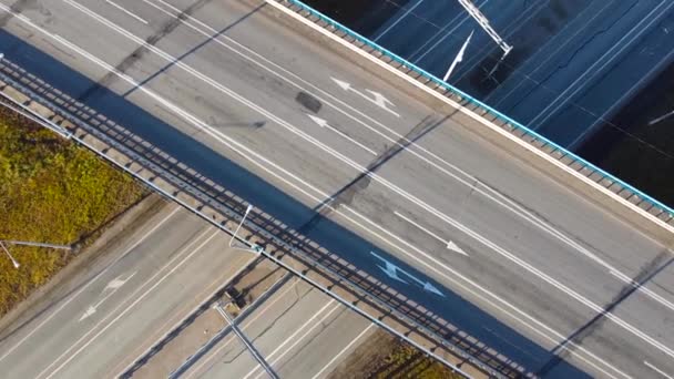 Luftaufnahme einer mehrstöckigen Autobahn-Kreuzung mit fahrenden Autos. Filmdrohne bei Sonnenuntergang über Landstraße mit umstürzenden Bäumen gefilmt — Stockvideo