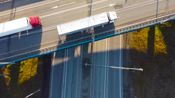 Luchtdrone uitzicht op de snelweg multi-level kruising weg met bewegende auto 's. Cinematografische drone schot vliegen over land weg met dalende bomen bij zonsondergang — Stockvideo