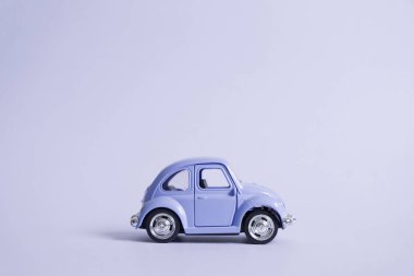 Omsk, Rusya - 26 Mayıs 2019: Pantone 2022 mavi arka planda renkli retro oyuncak araba. Sevgililer Günü. Çiçek teslimatı. 8 Mart, Uluslararası Mutlu Kadınlar Günü. Yaz yolculuğu konsepti. Taksi.