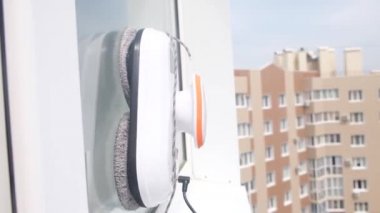 Robot temizleyici kirli pencerenin dışında çalışıyor. Evi akıllı aletlerle temizlemek. Pencereleri temizlemek için otomatik vakumlu robotlar, ev için bir asistan