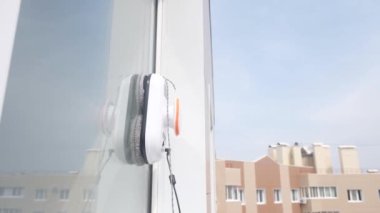 Robot temizleyici kirli pencerenin dışında çalışıyor. Evi akıllı aletlerle temizlemek. Pencereleri temizlemek için otomatik vakumlu robotlar, ev için bir asistan