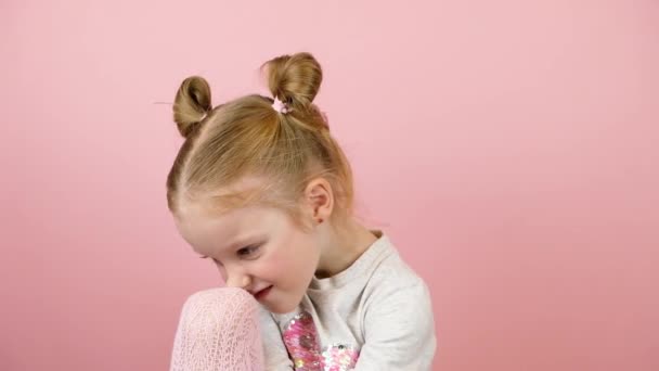 Trauriges kleines blondes Mädchen auf rosa Hintergrund. Valentinstag oder Muttertag Konzept — Stockvideo