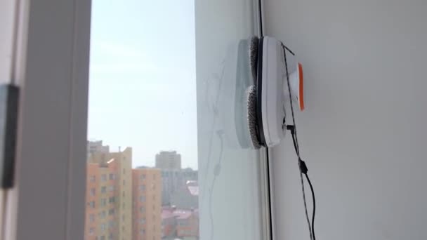 Robotul de curățare a ferestrelor funcționează pe fereastra murdară. Curățarea casei cu dispozitive inteligente. Roboți automați de vid pentru curățarea ferestrelor, un asistent pentru casă — Videoclip de stoc