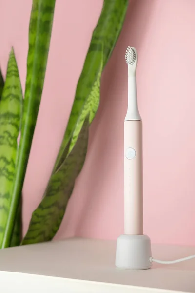 New modern ultrasonic toothbrushes. Dental care supplies with green leaves on pink pastel background. Oral hygiene, gum health, healthy teeth. Dental products Ultrasonic vibration toothbrush. — Stock Photo, Image