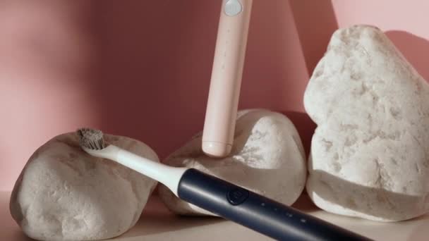 새로운 현대 초음파 칫솔. 턱 모델 과 치과 치료는 분홍빛 파스텔 배경에 대한 것이다. 구강 위생, 치아 와 잇몸 건강, 건강 한 치아. 치과 제품 초음파 진동 칫솔. — 비디오