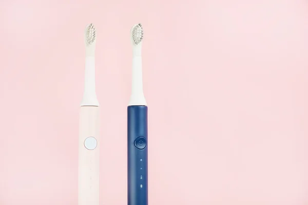 Two new modern ultrasonic toothbrushes. Dental care supplies on pink pastel background. Oral hygiene, dental and gum health, healthy teeth. Dental products Ultrasonic vibration toothbrush. — Stock Photo, Image