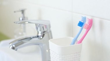 Yeni ultrasonik elektrikli diş fırçası için eski fırçaları değiştiren bir kadın. Profesyonel ağız bakımı kavramı ve sağlıklı dişler. Sonik akıllı diş fırçası kullanarak. Günlük hayat ve rutin.