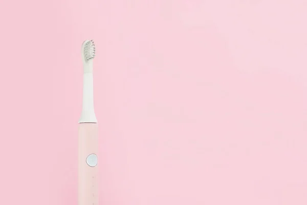 Nieuwe moderne ultrasone tandenborstel. Jaw model en tandheelkundige verzorging levert op roze pastel achtergrond. Orale hygiëne, tandheelkundige en tandvlees gezondheid, gezonde tanden. Tandheelkundige producten Ultrasone triltandenborstel. — Stockfoto