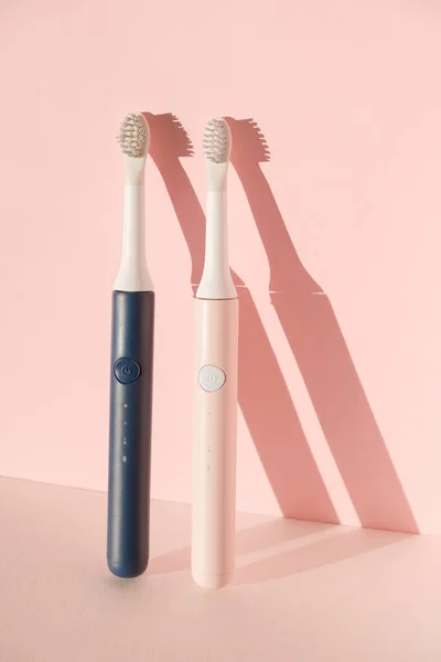Two new modern ultrasonic toothbrushes. Dental care supplies on pink pastel background. Oral hygiene, dental and gum health, healthy teeth. Dental products Ultrasonic vibration toothbrush. — Stock Photo, Image