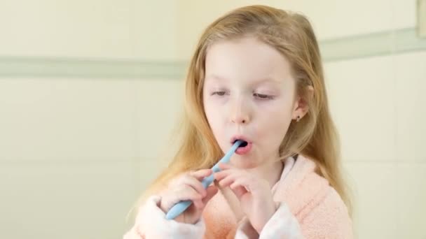 Feliz sorridente menina escova dentes usando escova de dentes elétrica ultra-sônica no banheiro em casa. Higiene oral, saúde dentária e gengival, dentes saudáveis. Vida diária e rotina. — Vídeo de Stock